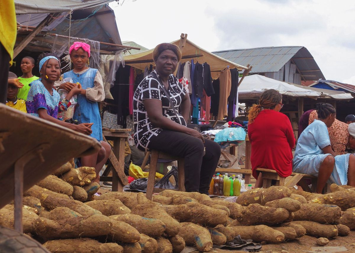 Traders selling produce and clothing at an outdoor market stall