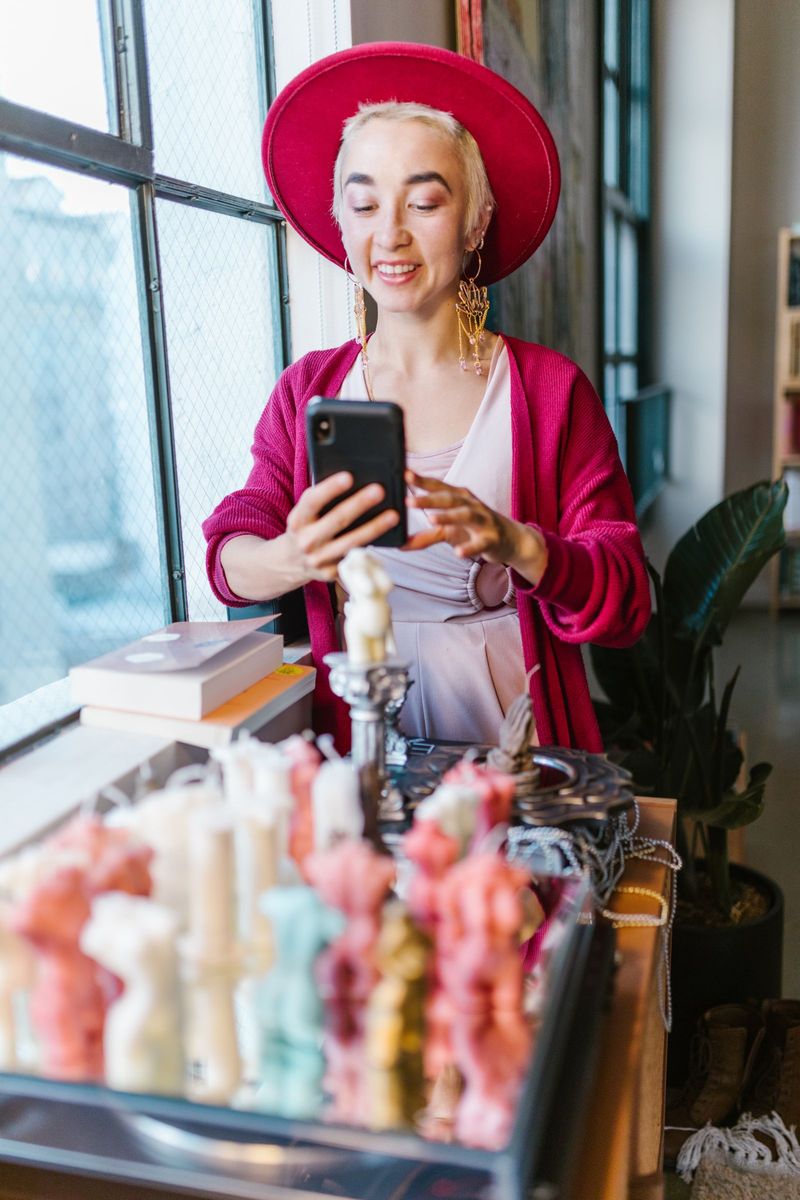 Small business owner photographing handmade candles on her phone for Instagram